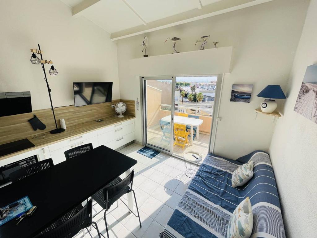 - un salon avec un canapé et une table à manger dans l'établissement Appartement rénové proche plage avec parking privatif - FR-1-723-124, au Cap d'Agde