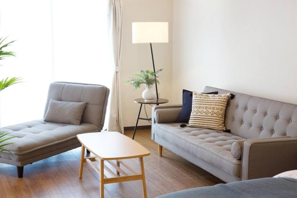 a living room with a couch and a chair at リバーサイドISHIGAKI 赤瓦A棟 in Tunugusuku