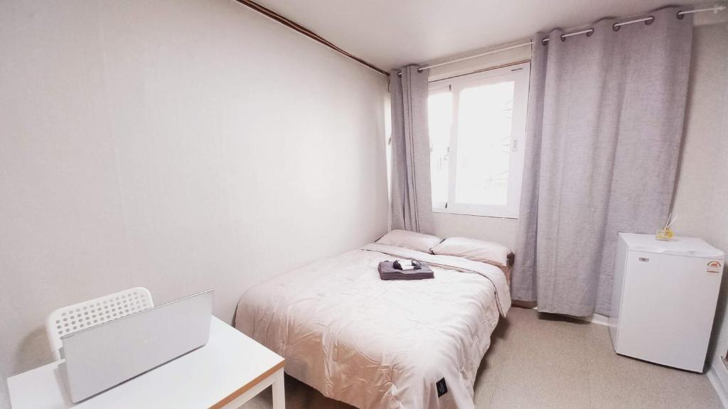 a bedroom with two beds and a desk and a window at 1975 Yurim Inn in Seoul