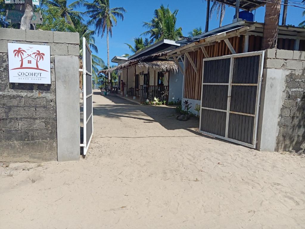 a building with a sign on the side of a street at CocoHut Beach House in Locaroc