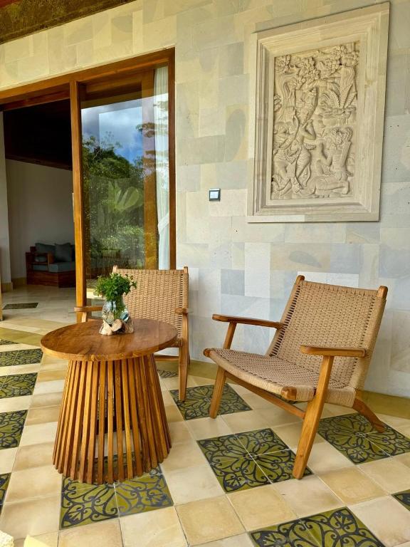 a patio with two chairs and a table and a bench at Abian Ayu Villa in Sidemen