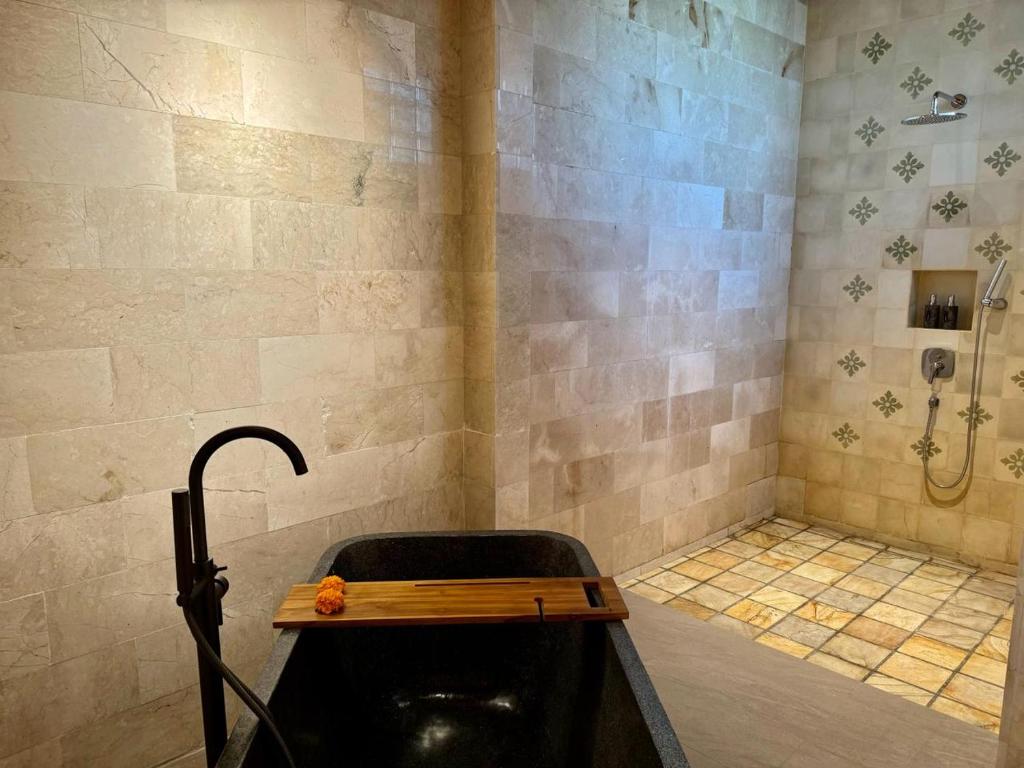 a bathroom with a bath tub and a shower at Abian Ayu Villa in Sidemen