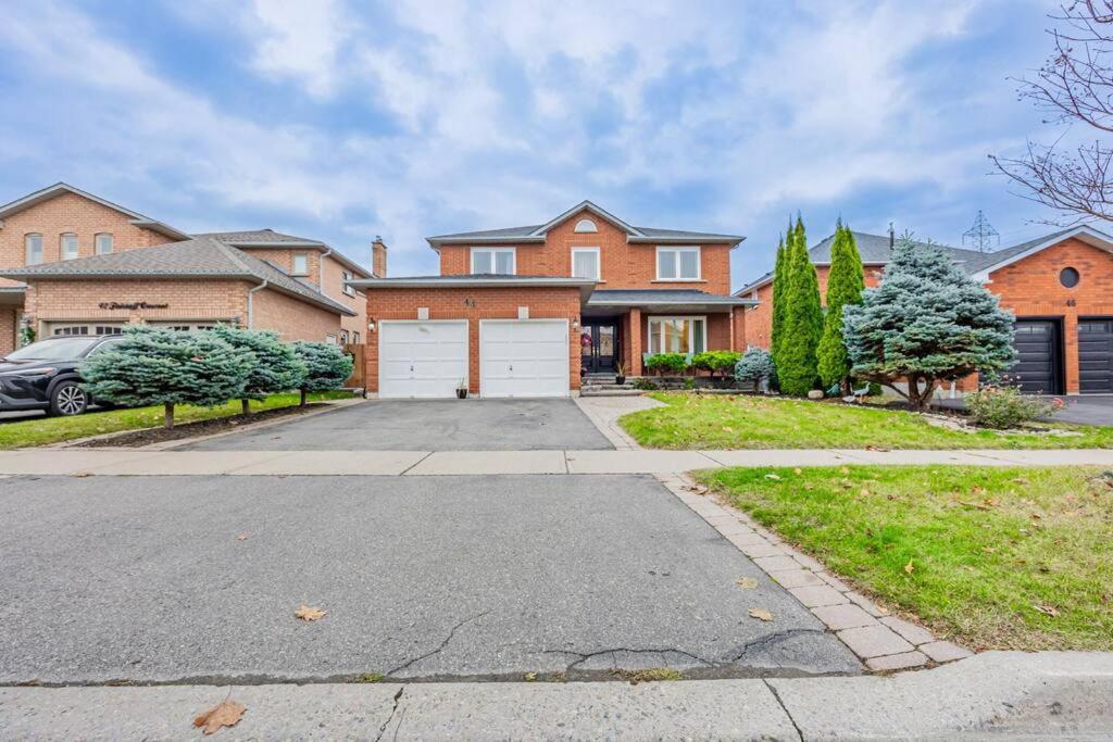 a large brick house with a driveway at Cozy Haven Retreat 2Bed Basement in Whitby