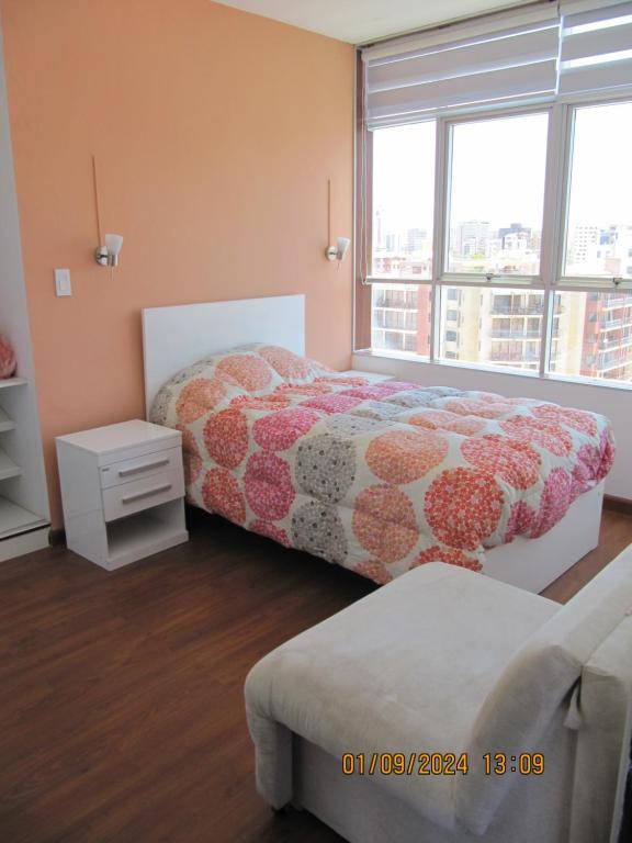 a bedroom with two beds and a large window at Departamento Familiar Portales in Cochabamba