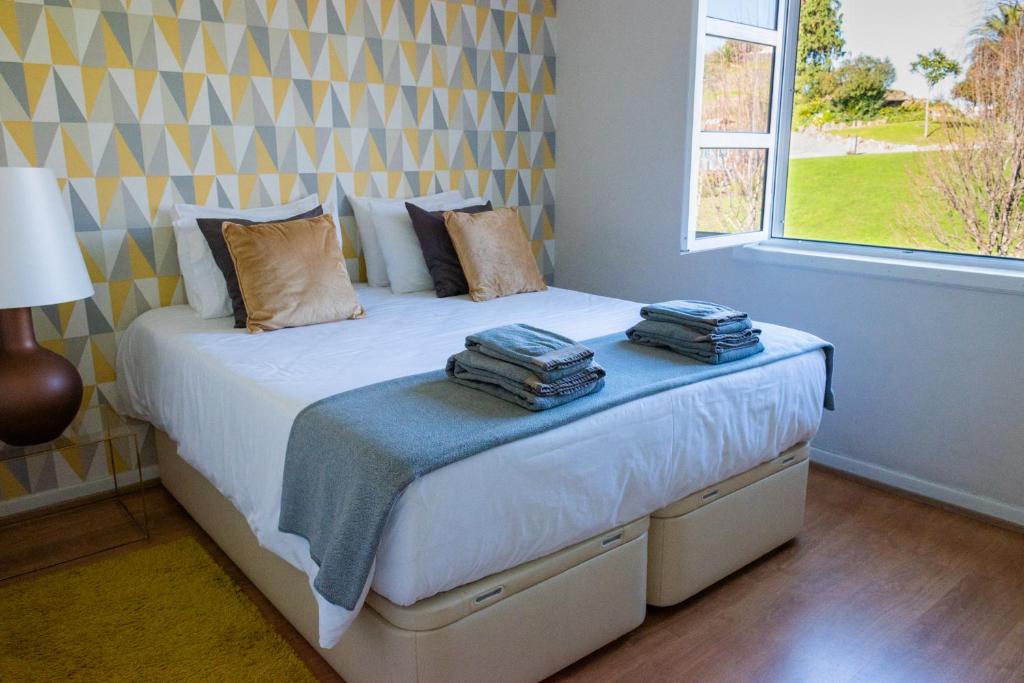 um quarto com uma cama com duas toalhas em North Star Flats @ Dom Luís I Bridge em Vila Nova de Gaia