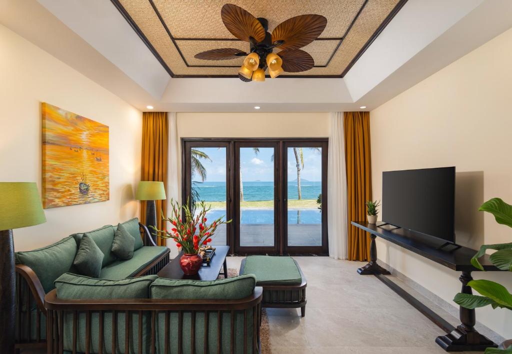a living room with a couch and a ceiling fan at Palm Garden Beach Resort & Spa in Hoi An