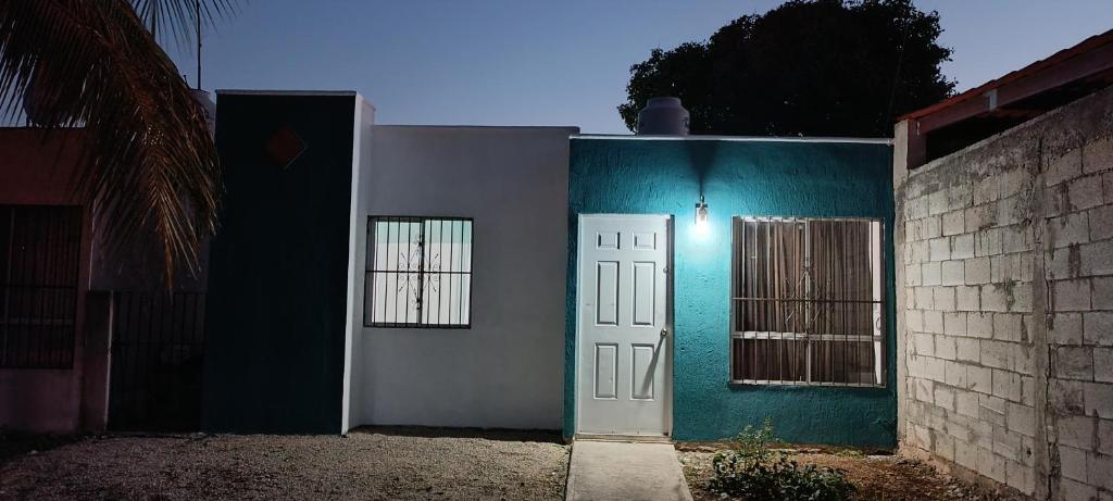 a house with a blue wall and a white door at alojamiento económico in Mérida