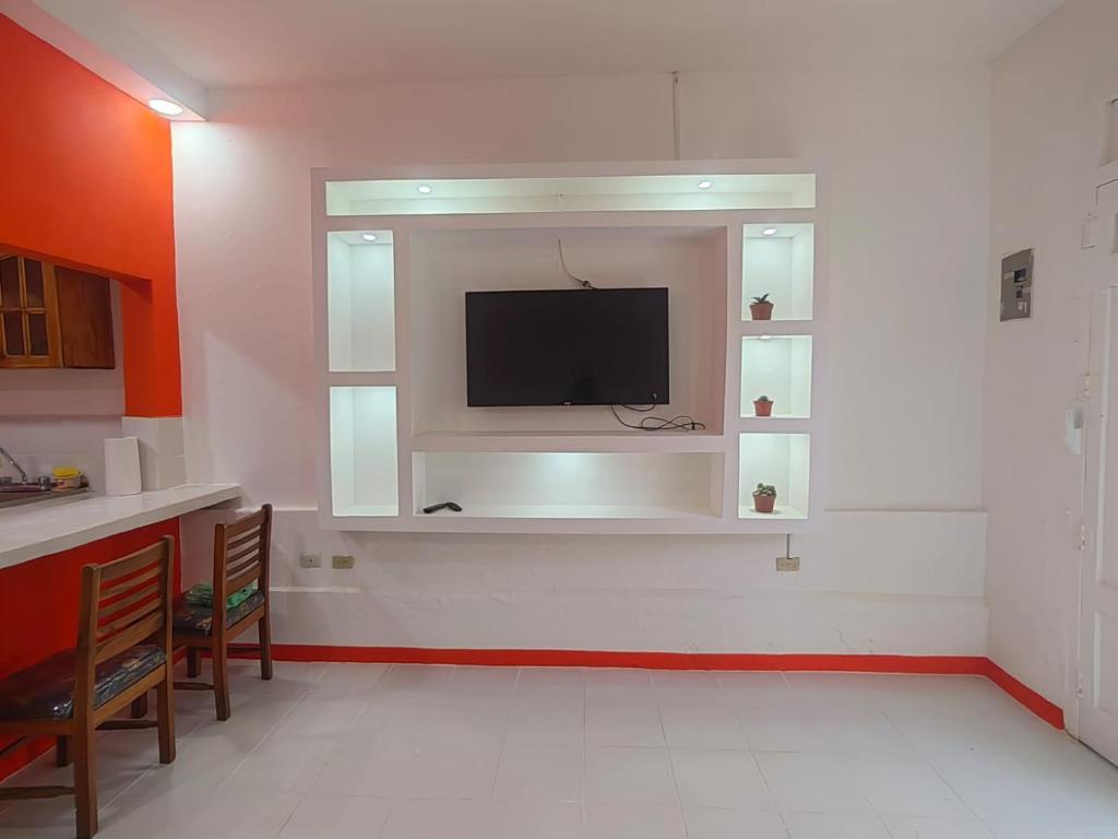 een woonkamer met een flatscreen-tv aan de muur bij Casa Naranja in Granada