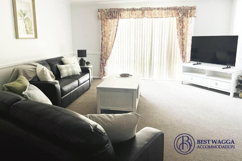 a living room with a couch and a tv at Suburban Bliss - Elegant Villa 2 in Wagga Wagga