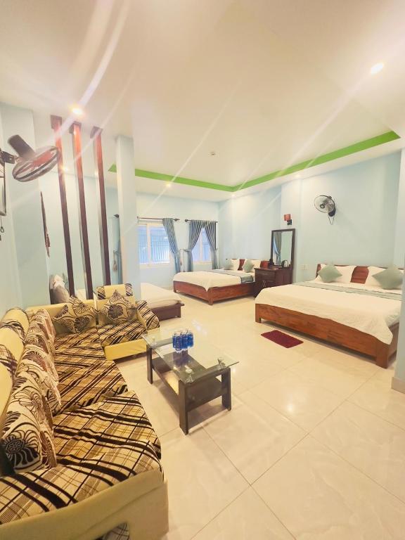 a living room with two beds and a couch at Anh Vu Hotel Phú Quốc in Phu Quoc