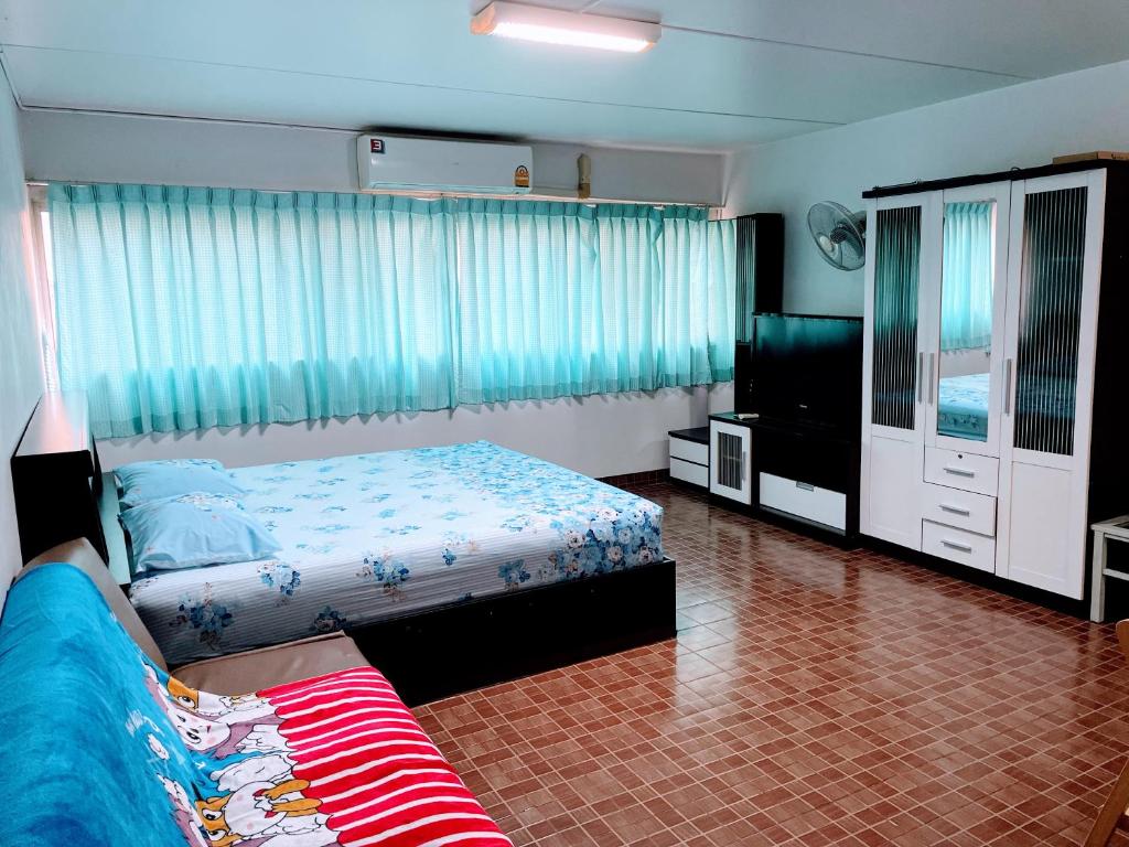 een slaapkamer met een bed en een flatscreen-tv bij Muangthong C3,C4near Impact in Nonthaburi