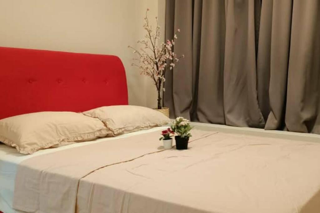 Una cama con cabecero rojo y flores. en KB2712 - Cyberjaya-Netflix-Wifi- Parking-Pool, 1011, en Cyberjaya