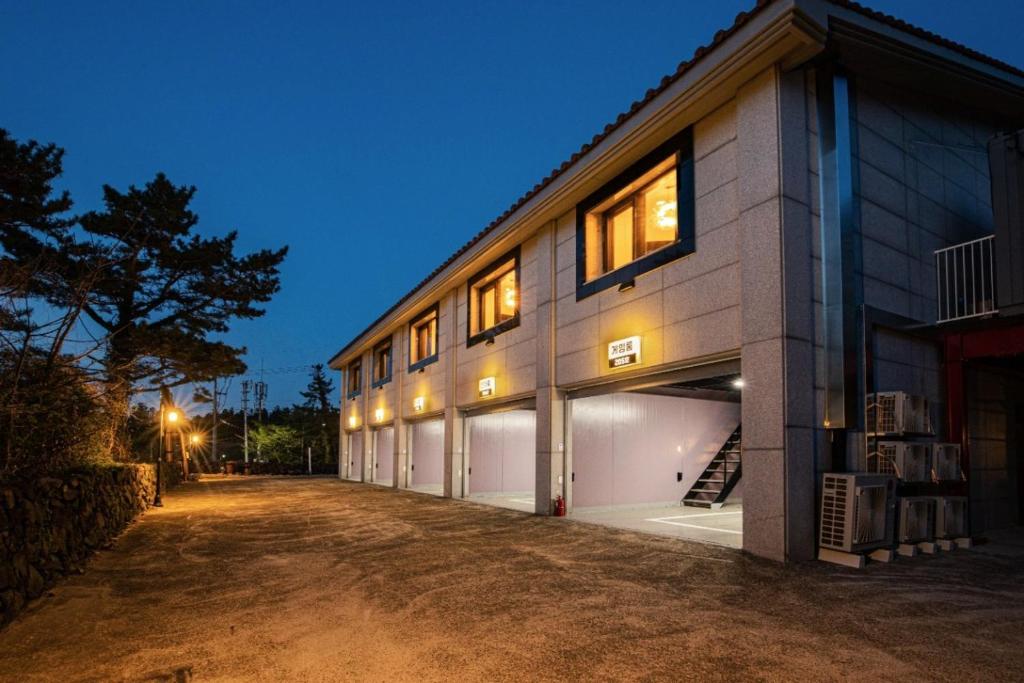 un edificio con dos puertas de garaje con luces encendidas en For You self service motel en Jeju