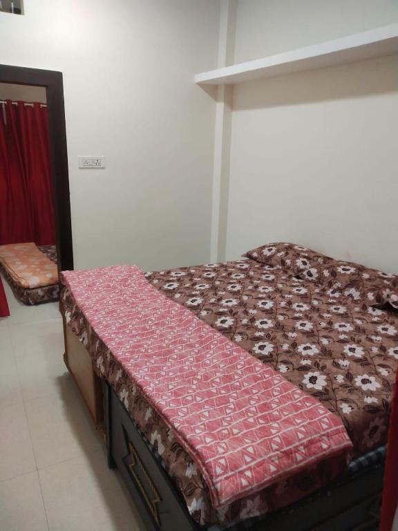 uma pequena cama num quarto com um colchão vermelho em Maa yatri niwas ( home stay) ujjain em Ujaim