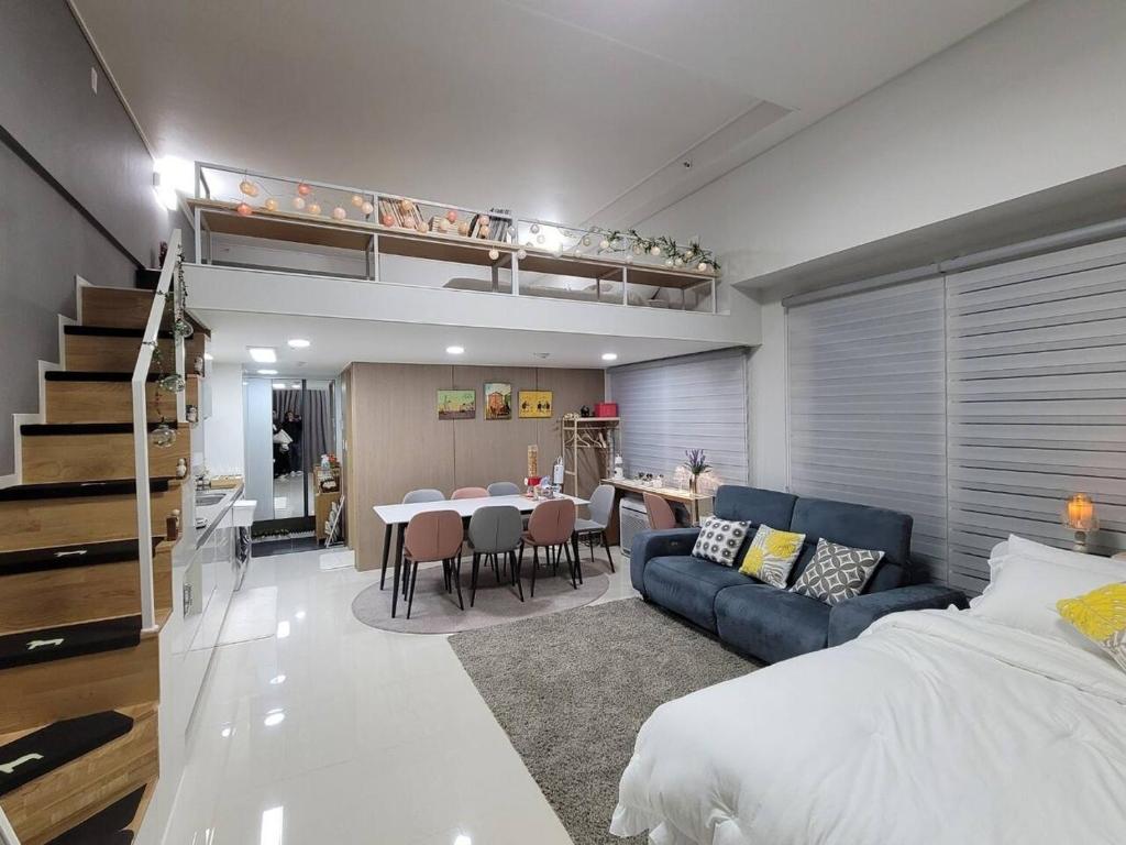 een woonkamer met een bed en een eetkamer bij Loco House in Incheon