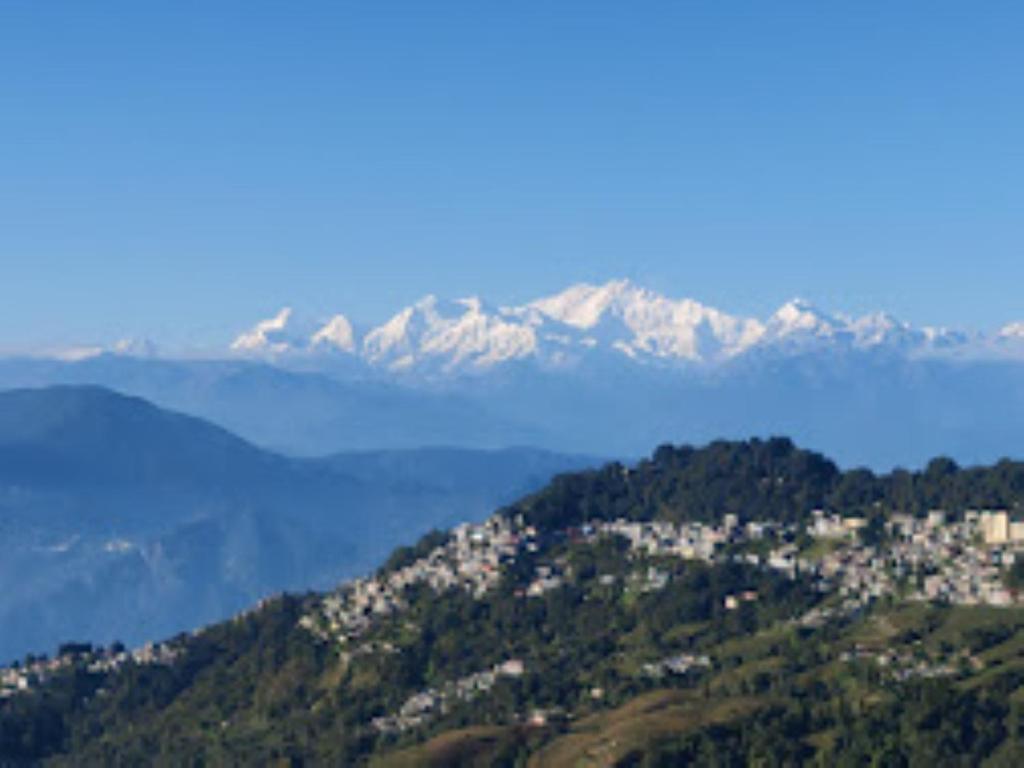 een uitzicht op een berg met besneeuwde bergen bij Hotel Kasturi Palace & Restaurant Darjeeling in Darjeeling