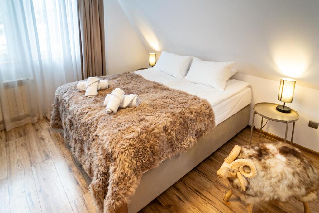 ein Schlafzimmer mit einem Bett mit zwei ausgestopften Tieren darauf in der Unterkunft Willa Owca i Baran in Zakopane
