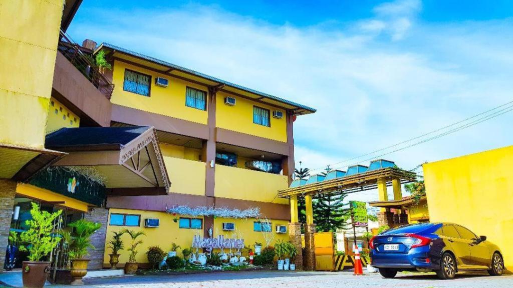 a car parked in front of a yellow building at Magallanes Square Hotel Inc. in Tagaytay