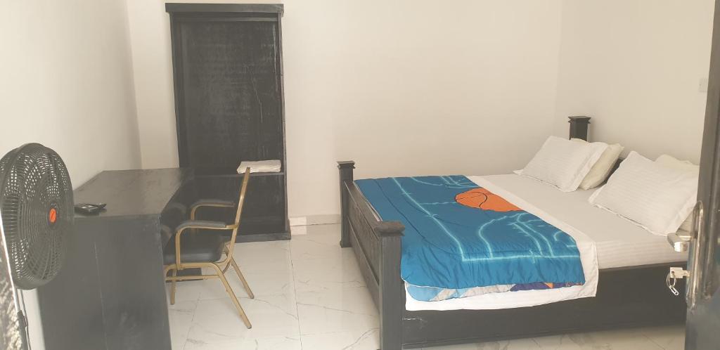 um quarto com uma cama, uma secretária e uma cadeira em Dakunaia 