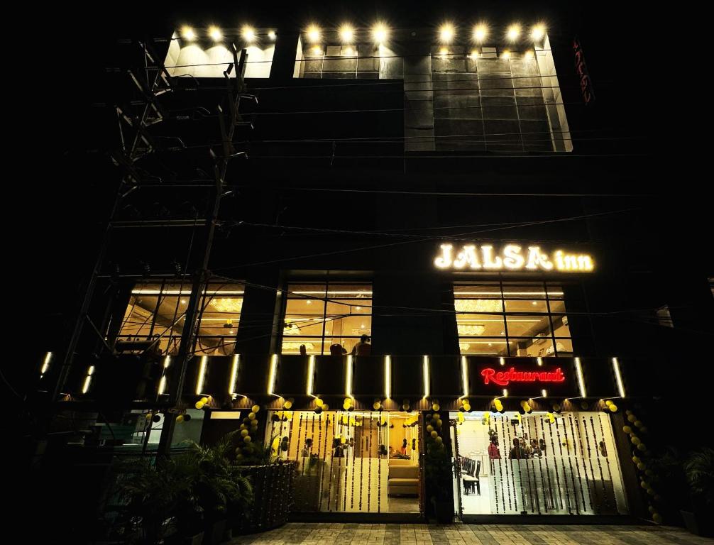 un bâtiment avec un panneau qui lit le bar jalegas la nuit dans l'établissement Jalsa inn, Bhopal, à Shamsgarh