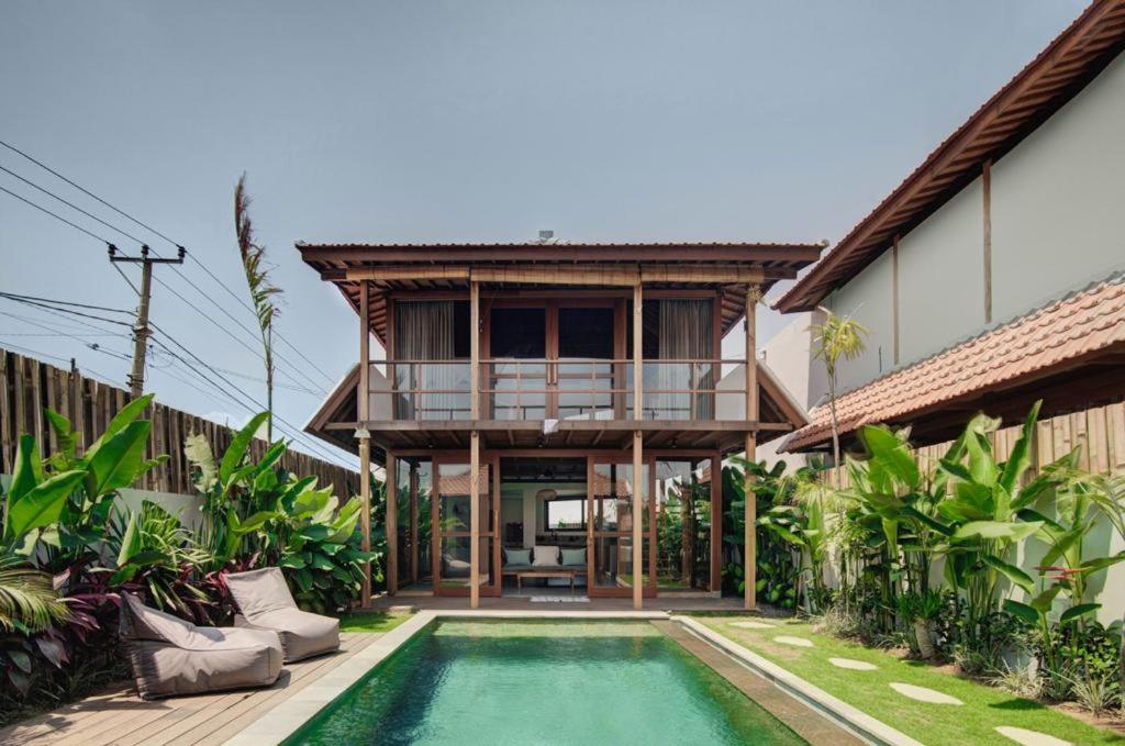 a villa with a swimming pool and a house at Villa Sunshine in Munggu