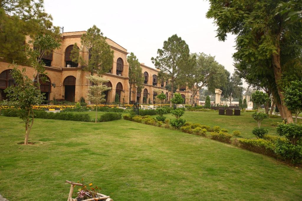 un jardín frente a un edificio en Peshawar Barracks by Shelton's Rezidor en Peshawar