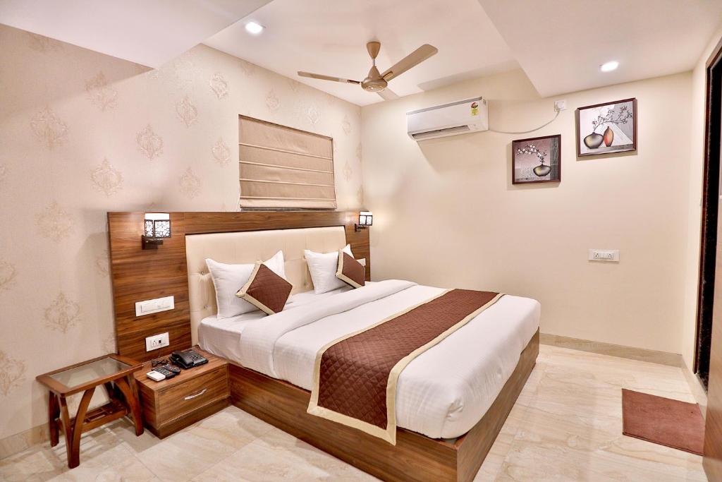 a bedroom with a bed and a ceiling fan at FabHotel Prime Candlewood by A plus Hospitality in Udaipur