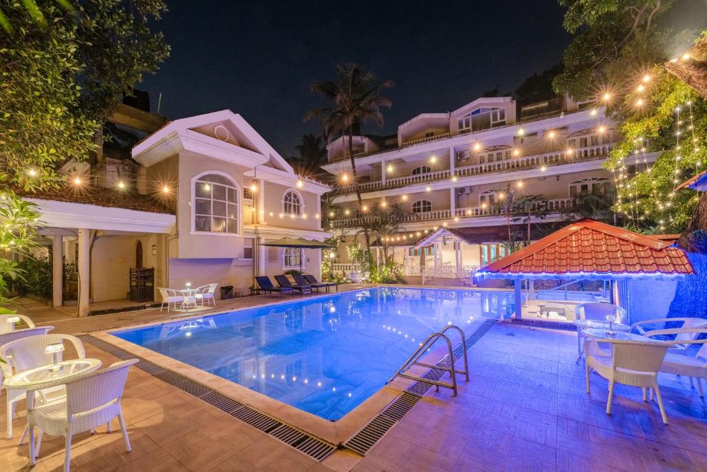 a swimming pool in front of a hotel at night at Joia Do Mar Resort - Calangute in Calangute