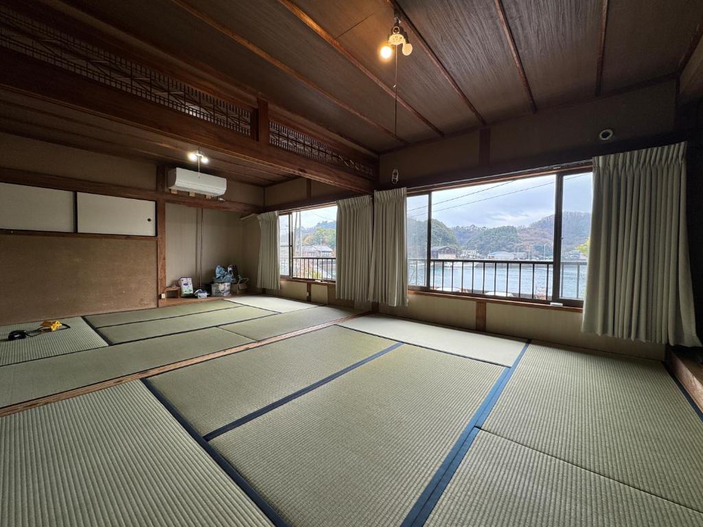 a room with a row of mats in front of a window at すくもBOX in Sukumo