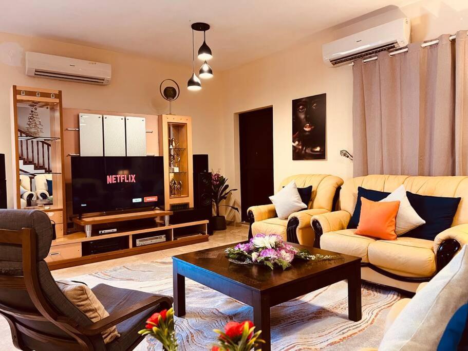 ONE Prestine Beach Villa في مسقط: غرفة معيشة مع أريكة وتلفزيون