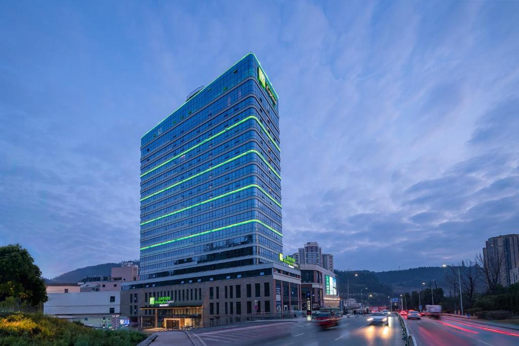 un edificio alto de cristal al lado de una calle en Holiday Inn Express Bazhong Center, an IHG Hotel, en Bazhong
