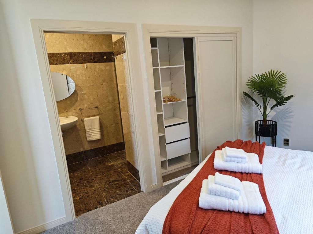 un baño con una cama con toallas. en Vegans on Lillington en Auckland