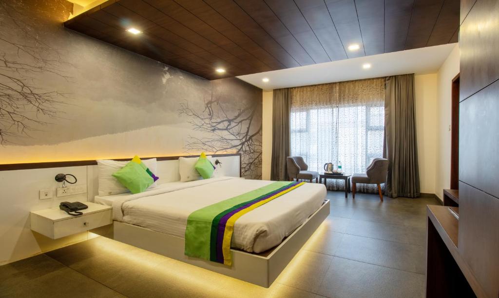 a hotel room with a bed and a desk at Treebo Trend Brahma - Wayanad in Mananthavady