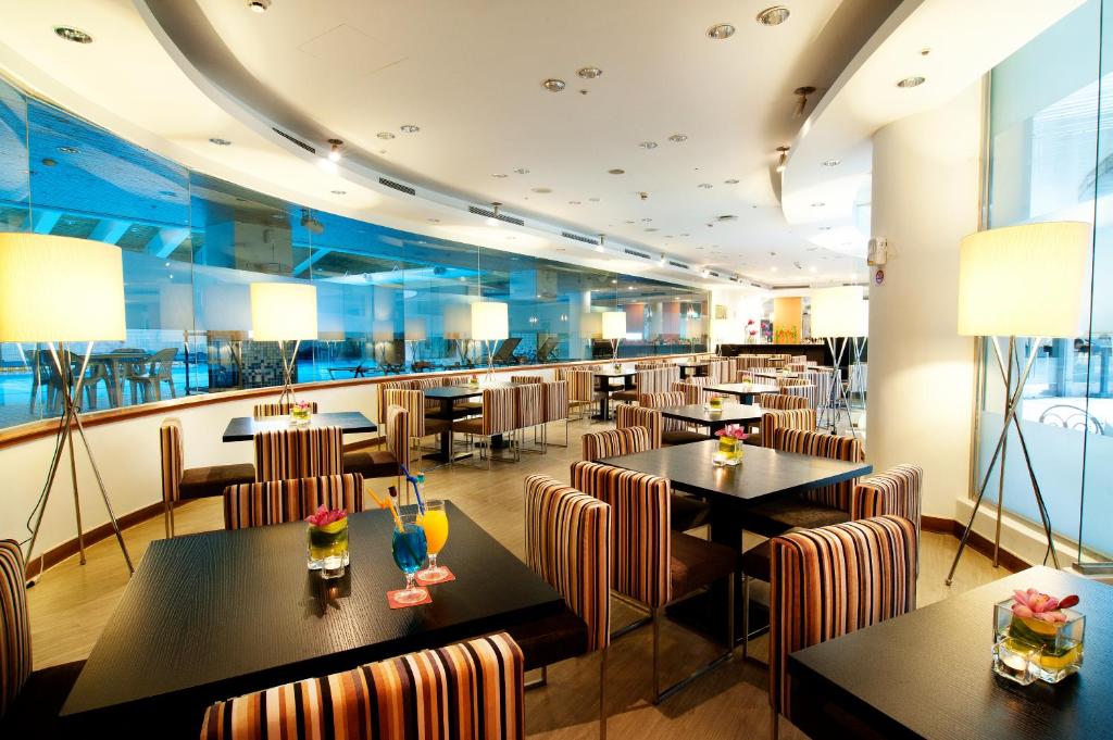 a restaurant with tables and chairs and a bar at Howard Civil Service International House in Taipei