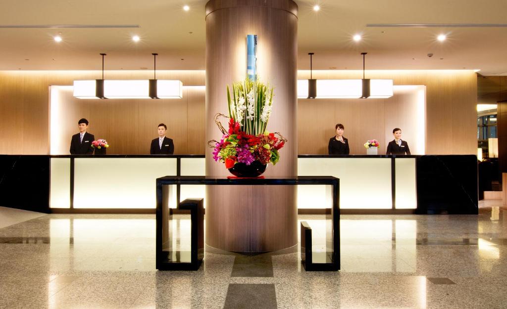 a lobby with a table with a vase of flowers on it at Howard Civil Service International House in Taipei