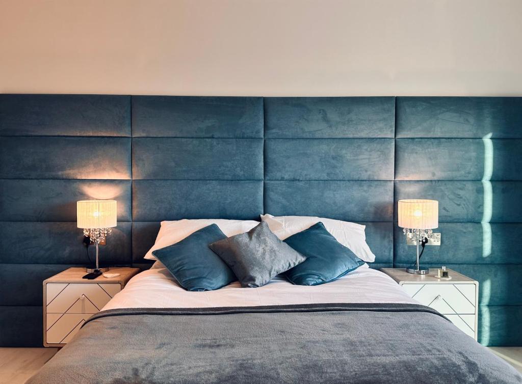 ニューキーにある34 Cliff Edge 2nd floor Newquay luxury sea-view residenceのベッドルーム1室(青いヘッドボード付きの大型ベッド1台付)