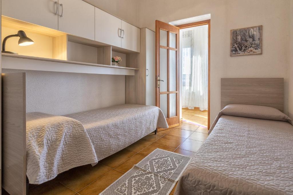 1 dormitorio con 2 camas en una habitación en Nausica's Apartment, en Trinità dʼAgultu