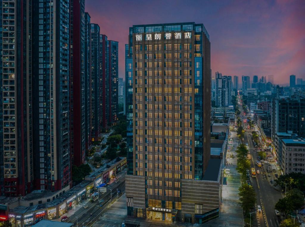 a tall building in the middle of a city at Rezen Longuu Hotel - Universiade Center Longgang Shenzhen in Longgang