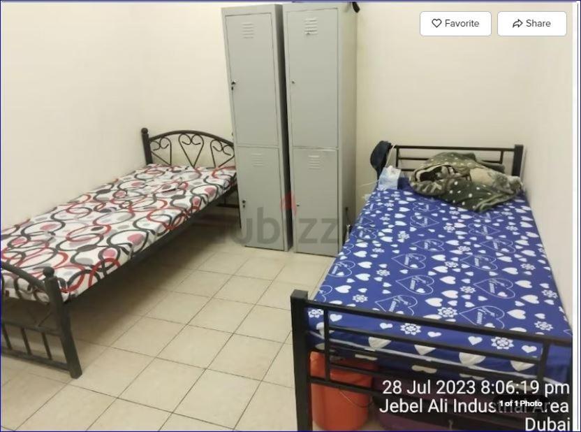 a small room with two beds in a room at Studio Flat in AWS in Dubai