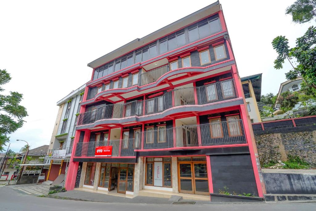 un edificio rojo al lado de una calle en OYO Life 90035 Merci Club, en Bandung