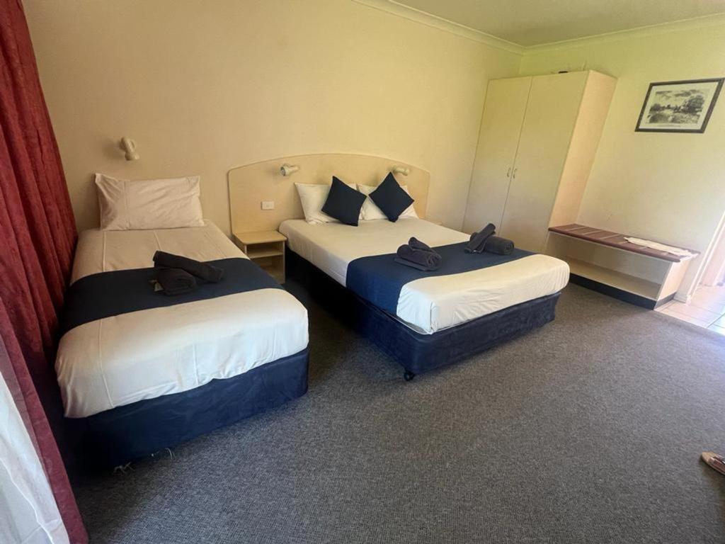 una habitación de hotel con 2 camas en una habitación en Outback Quarters Motel Hay and Restaurant, en Hay
