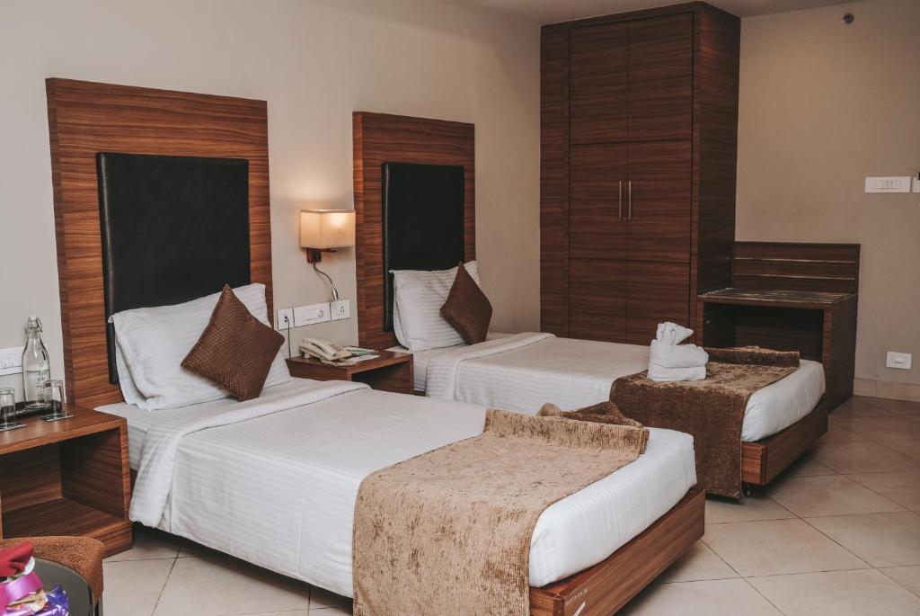 Postel nebo postele na pokoji v ubytování Peerless Hotel Durgapur