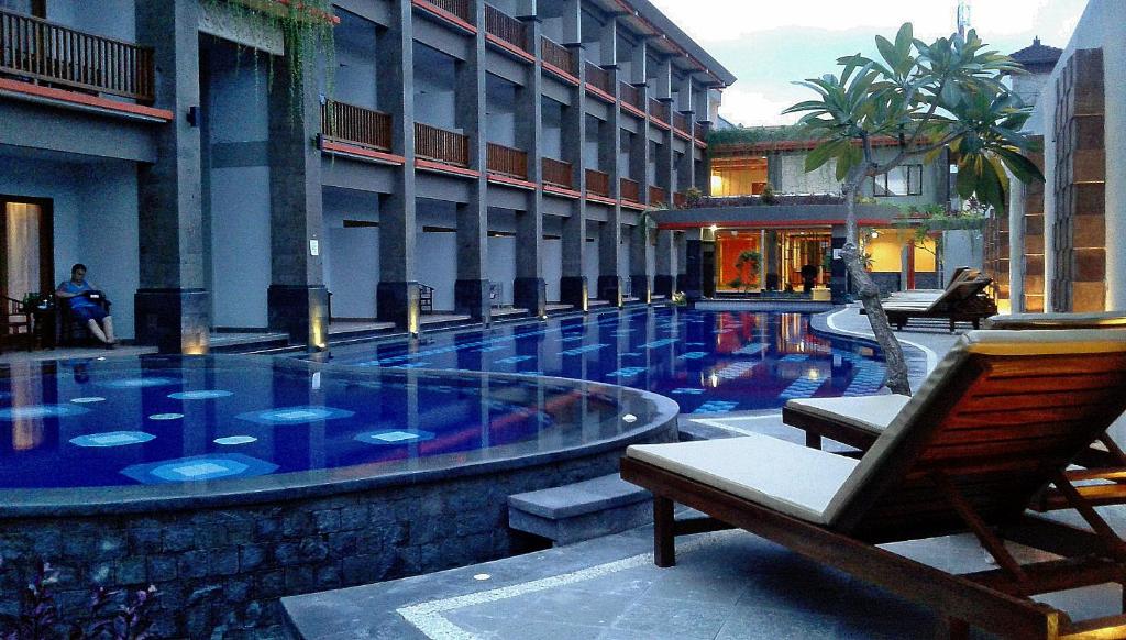 a swimming pool in the middle of a building at Grand Sinar Indah in Legian