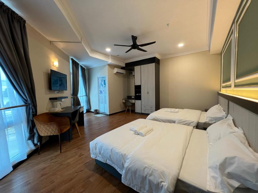 Cette chambre comprend deux lits et un ventilateur de plafond. dans l'établissement Alia Express Dey Hotel, à Kota Bharu