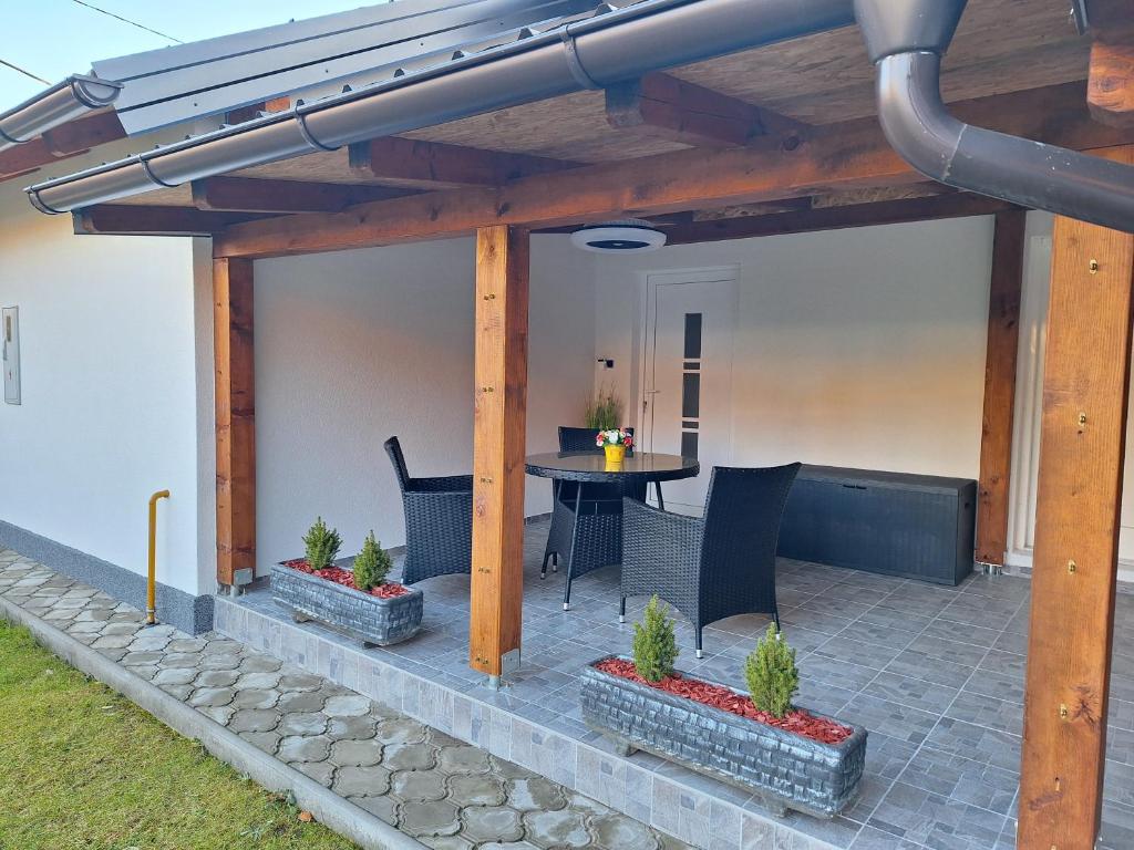 a covered patio with a table and chairs at Apartman Krajcer 