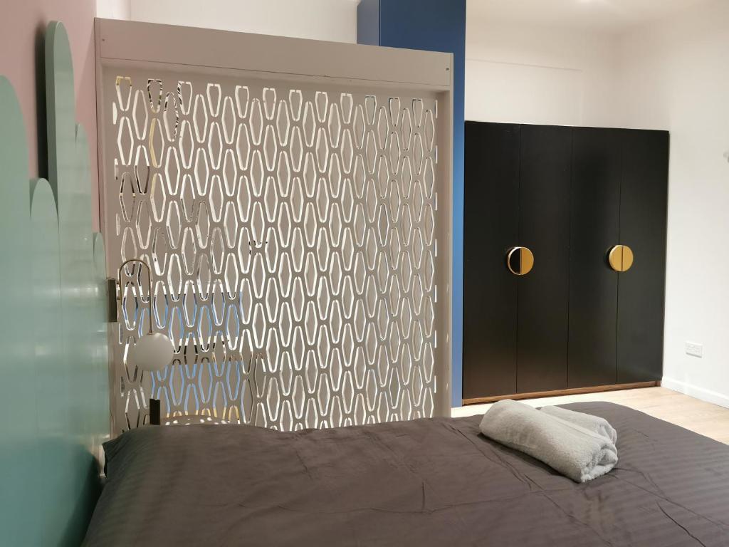 a bedroom with a bed and a wall with a door at Unique City Centre Apartments in Nicosia