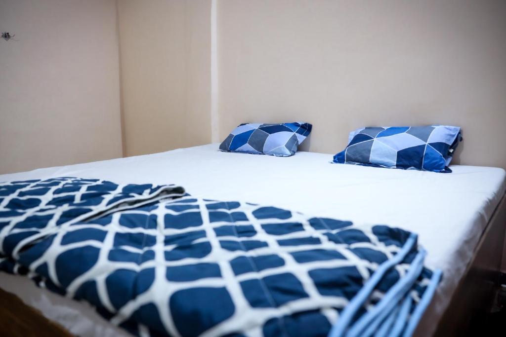 a bed with blue and white pillows on it at Blue Lagoon Redefined in Gokarna