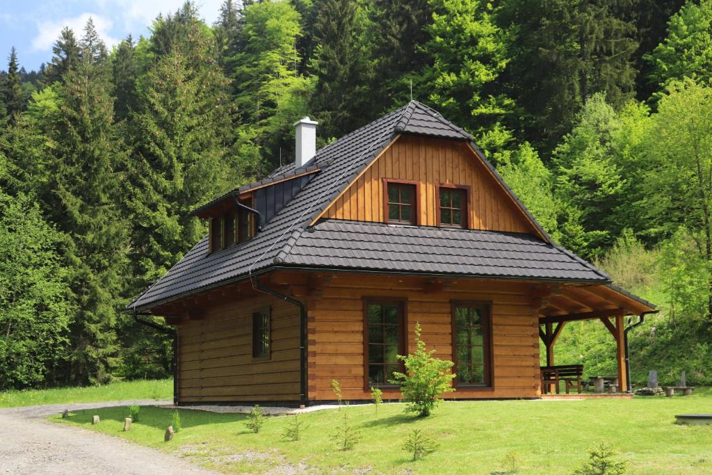 una piccola cabina in legno con tetto nero di Dřevěnice v Brodské a Nový Hrozenkov