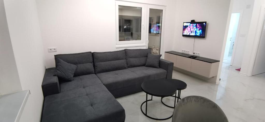 a living room with a couch and a tv at Apartman Marina stan na dan in Prijedor