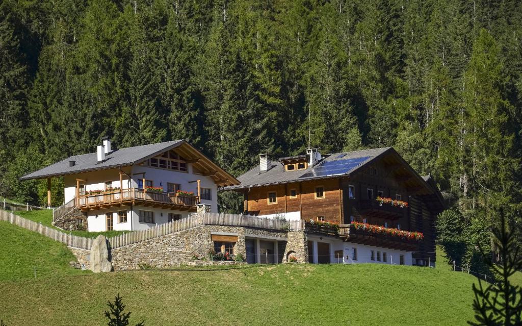 a large house sitting on top of a green hill at Thalhof Kornigl in Ultimo